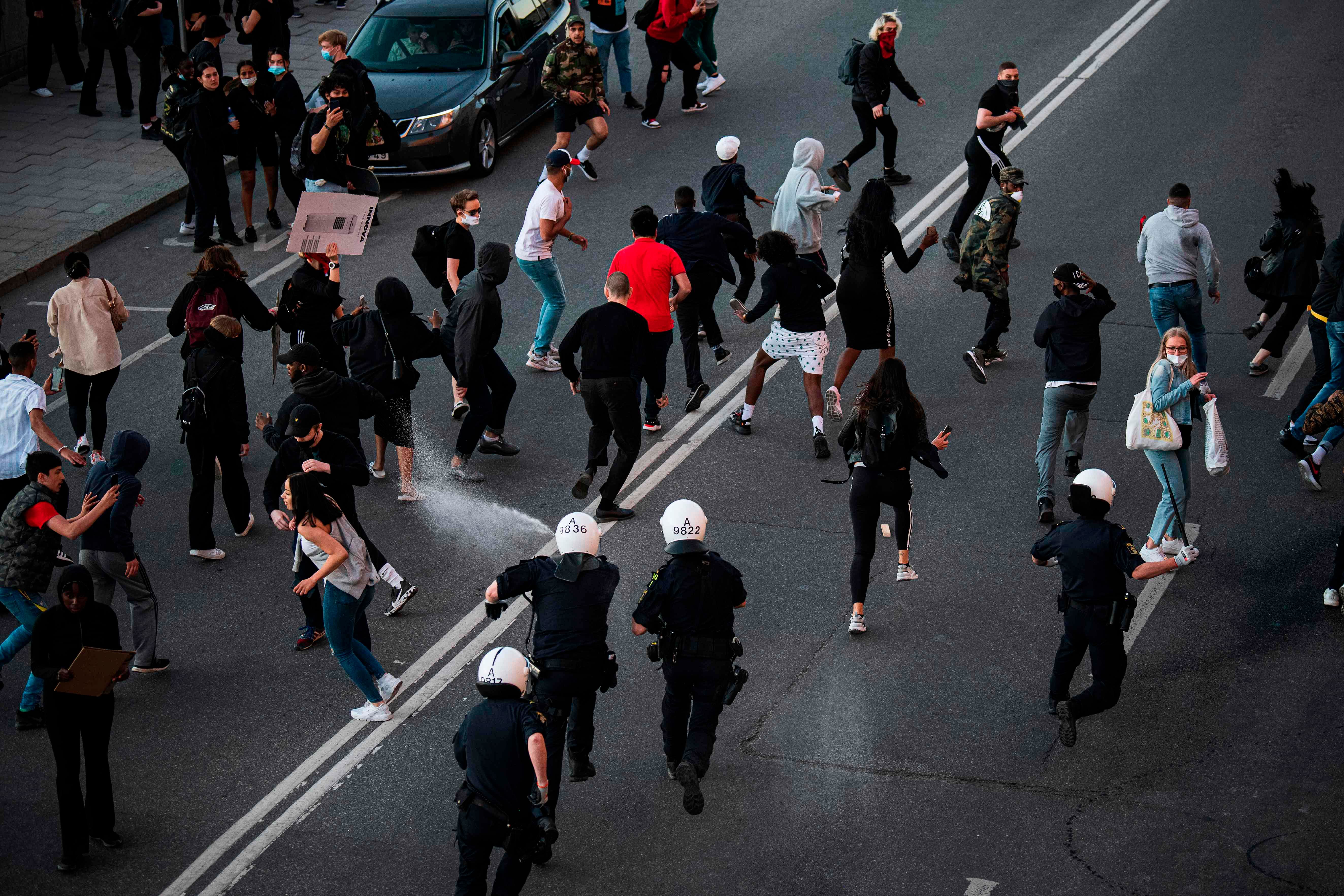 Protesters run as police use pepper spray during a Black Lives Matter demonstration in Stockholm, Sweden, on June 3, 2020, in solidarity with protests raging across the United States over the death of George Floyd. (Photo by AFP)