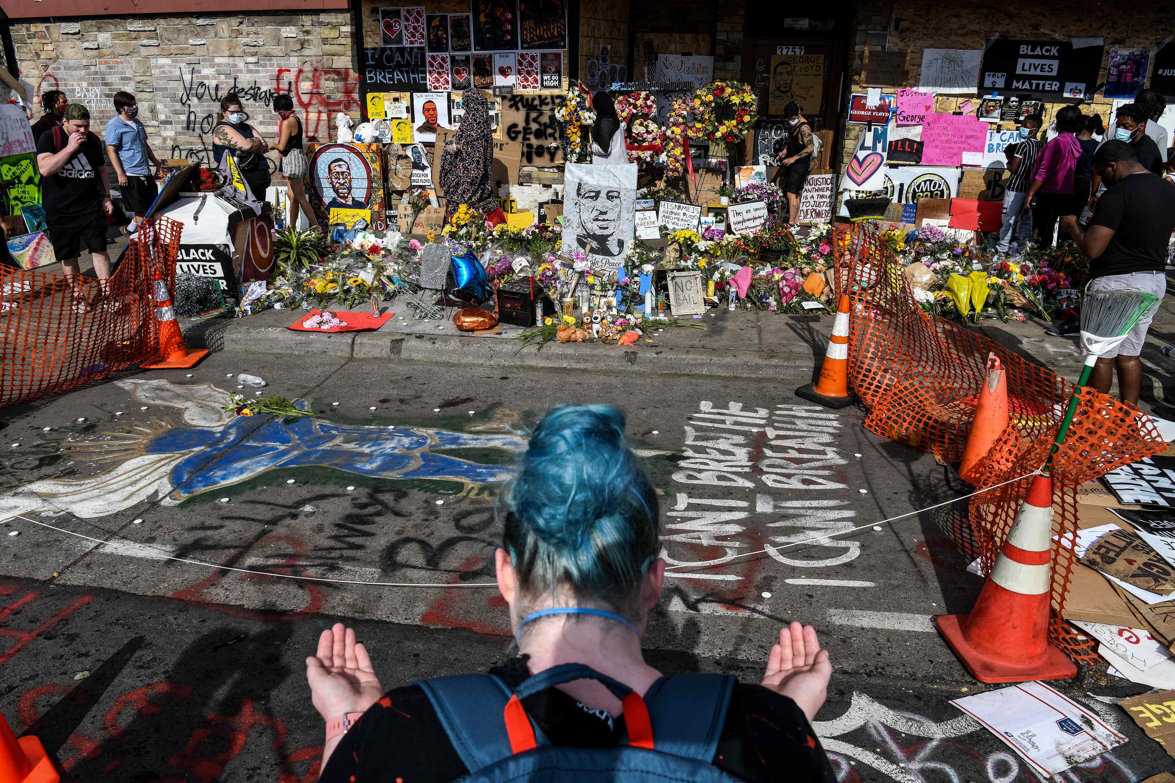 A woman offers prayers as she pays her respects at a makeshift memorial in honour of George Floyd, on June 3, 2020 in Minneapolis, Minnesota. Credit: AFP