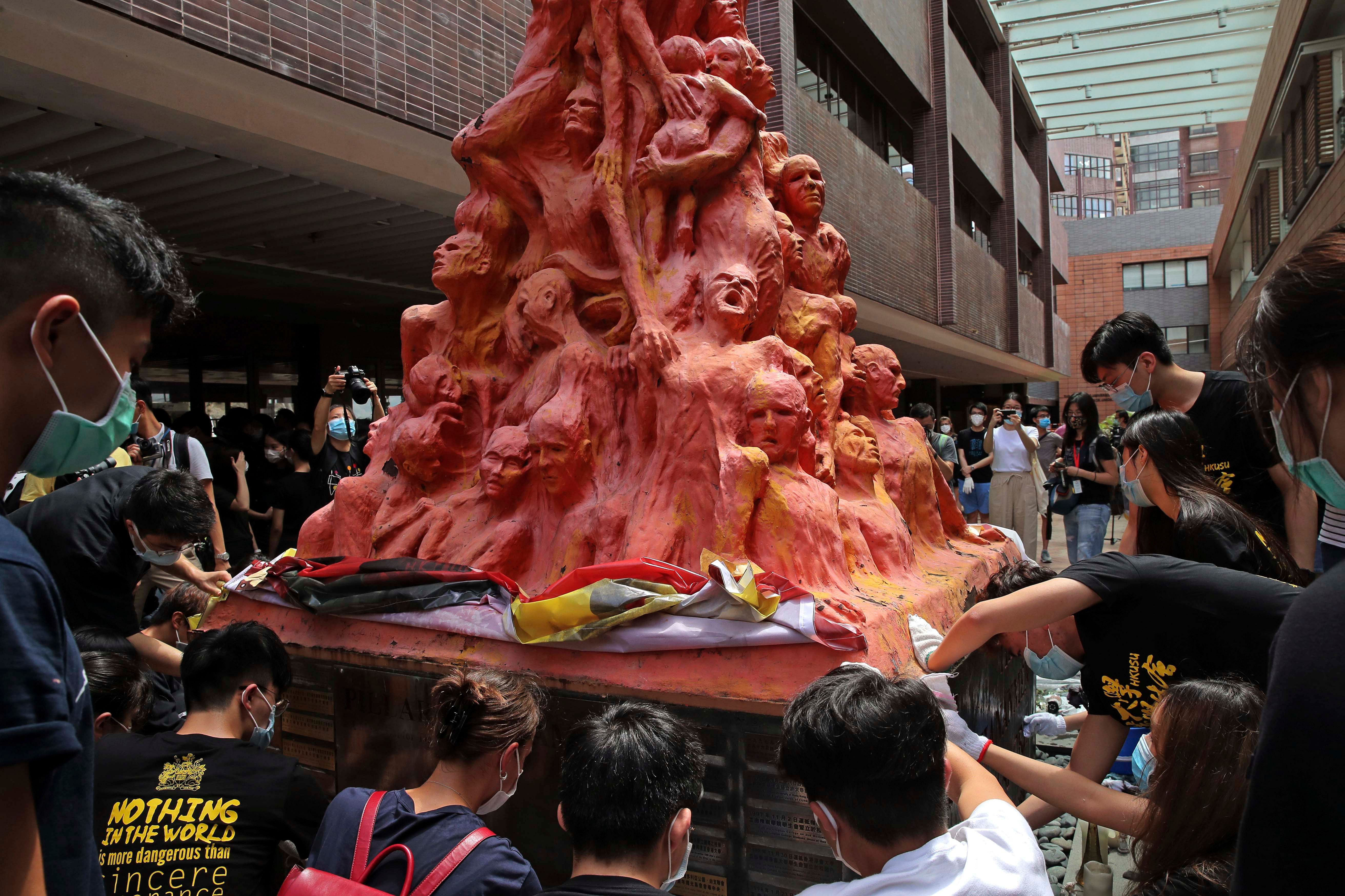 University students clean the "Pillar of Shame" statue, a memorial for those killed in the 1989 Tiananmen crackdown, at the University of Hong Kong, Thursday, June 4, 2020. China is tightening controls over dissidents while pro-democracy activists in Hong Kong and elsewhere try to mark the 31st anniversary of the crushing of the pro-democracy movement in Beijing's Tiananmen Square. Credit: AP/PTI
