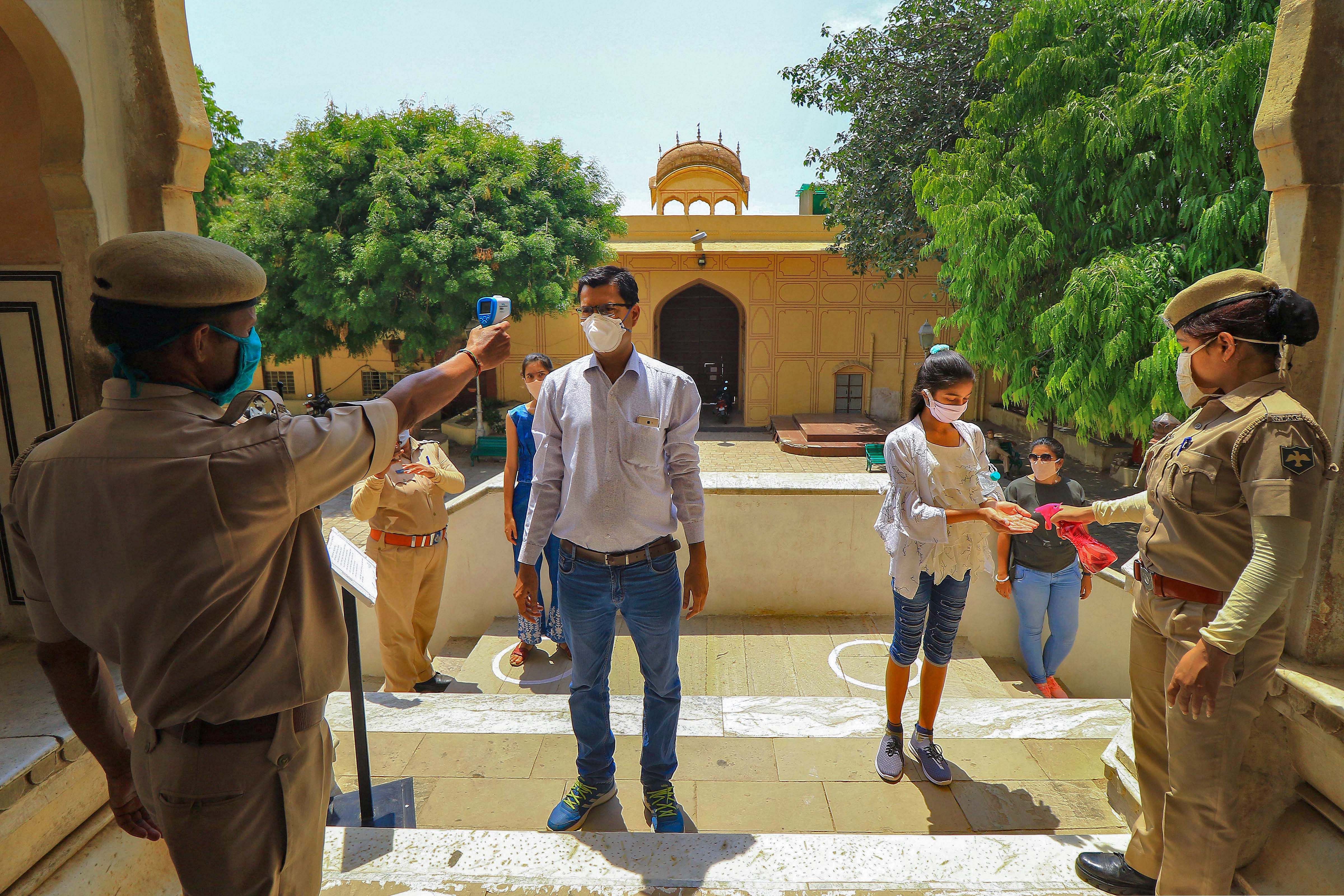 Tourists undergo thermal screening at Hawa Mahal after the authorities permitted to open monuments, forts and museums in the state, during the ongoing COVID-19 lockdown. (PTI Photo)