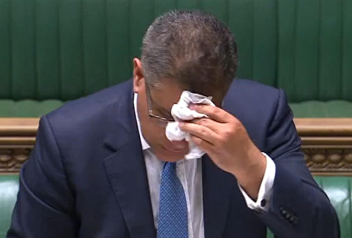 A video grab from footage broadcast by the UK Parliament's Parliamentary Recording Unit (PRU) shows Britain's Business Secretary Alok Sharma wiping his brow as he makes a statement in the House of Commons in London. AFP/PRU/Handout