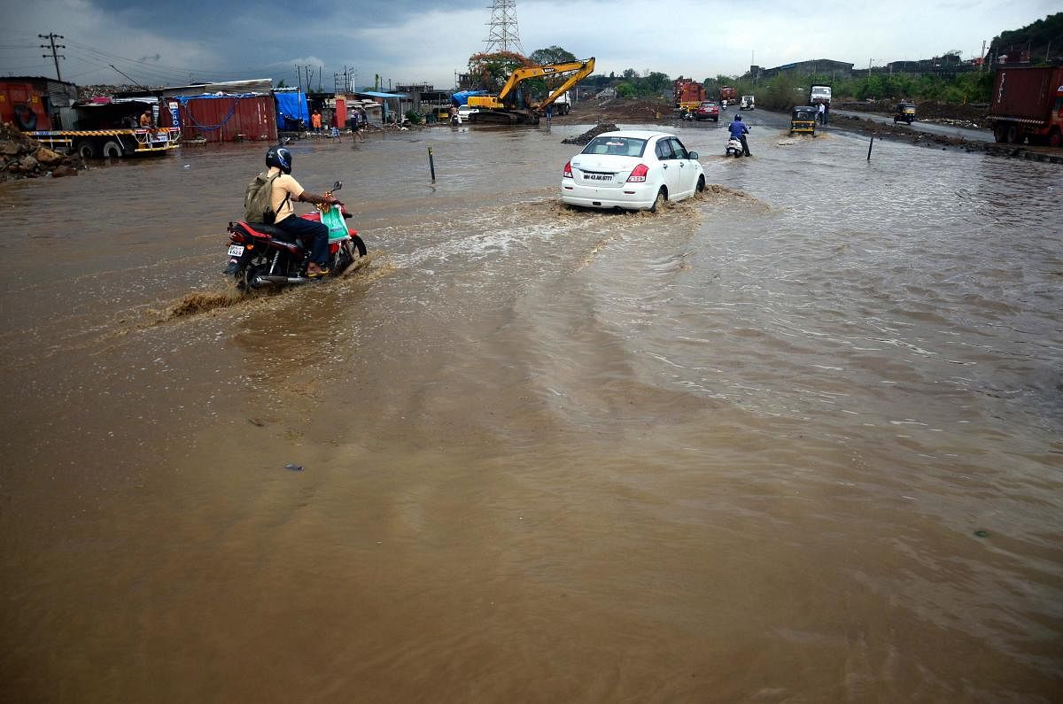 Vehicles ply on a waterlogged street following heavy rainfall, in the aftermath of Cyclone Nisarga, at Uran in Navi Mumbai. PTI