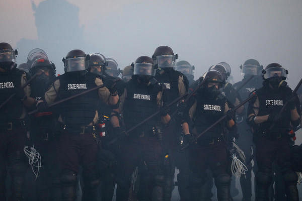 Police officers are seen amid tear gas as protesters continue to rally against the death in Minneapolis police custody of George Floyd, in Minneapolis, Minnesota, U.S. May 30, 2020. REUTERS