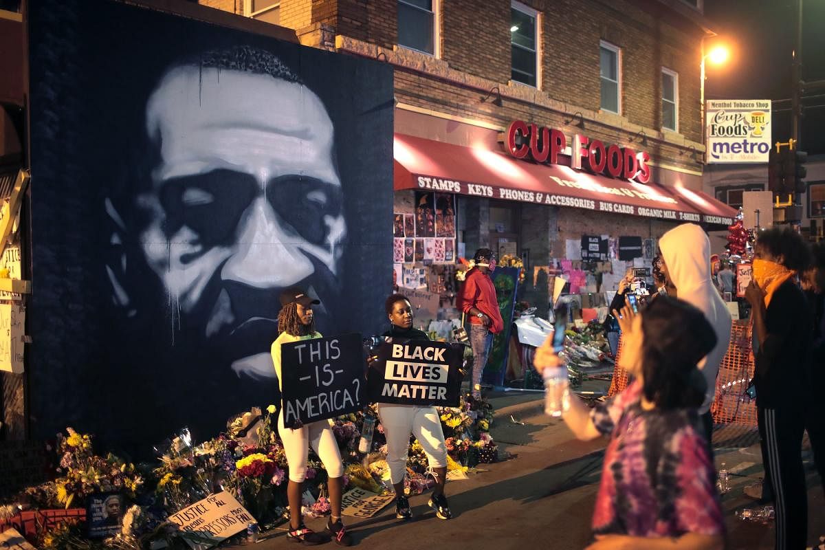 : People visit a memorial at the site where George Floyd was killed on June 3, 2020 in Minneapolis, Minnesota. Floyd died while in police custody on May 25, after former Minneapolis police officer Derek Chauvin kneeled on his neck for nine minutes while detaining him. Credit/AFP