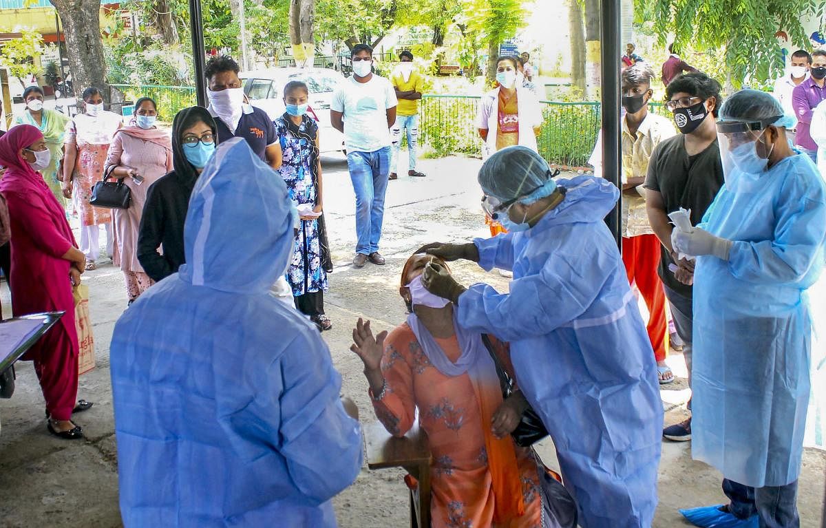 Health workers collect swab sample of a doctor for the COVID-19 test at a government dispensary, during the nationwide lockdown, in Patiala, Monday, June 1, 2020. Credit/PTI Photo
