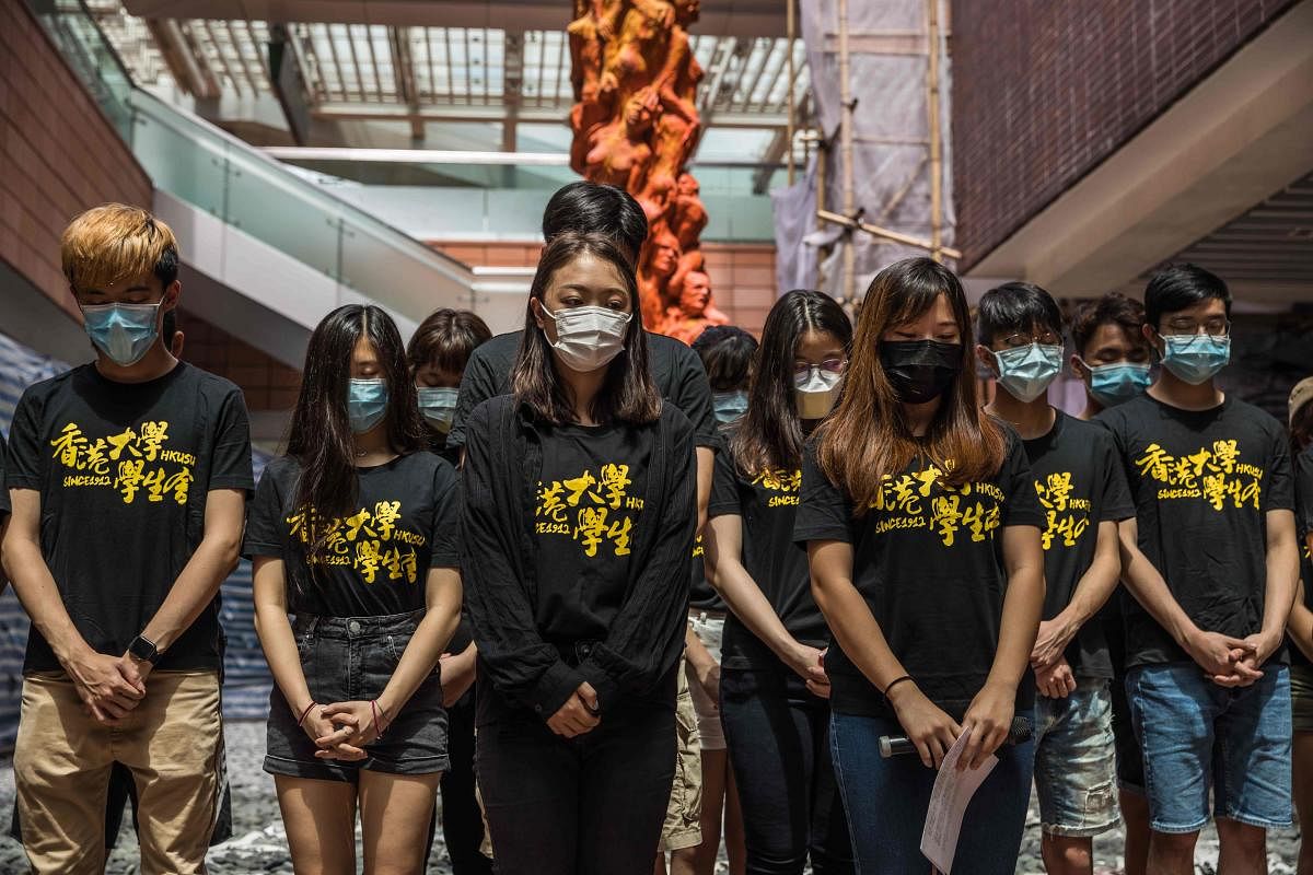 University students observe a minute of silence before cleaning the Pillar of Shame, a statue by Danish artist Jens Galschiot to remember the victims of the 1989 Tiananmen crackdown in Beijing, at The University of Hong Kong (HKU) in Hong Kong. AFP