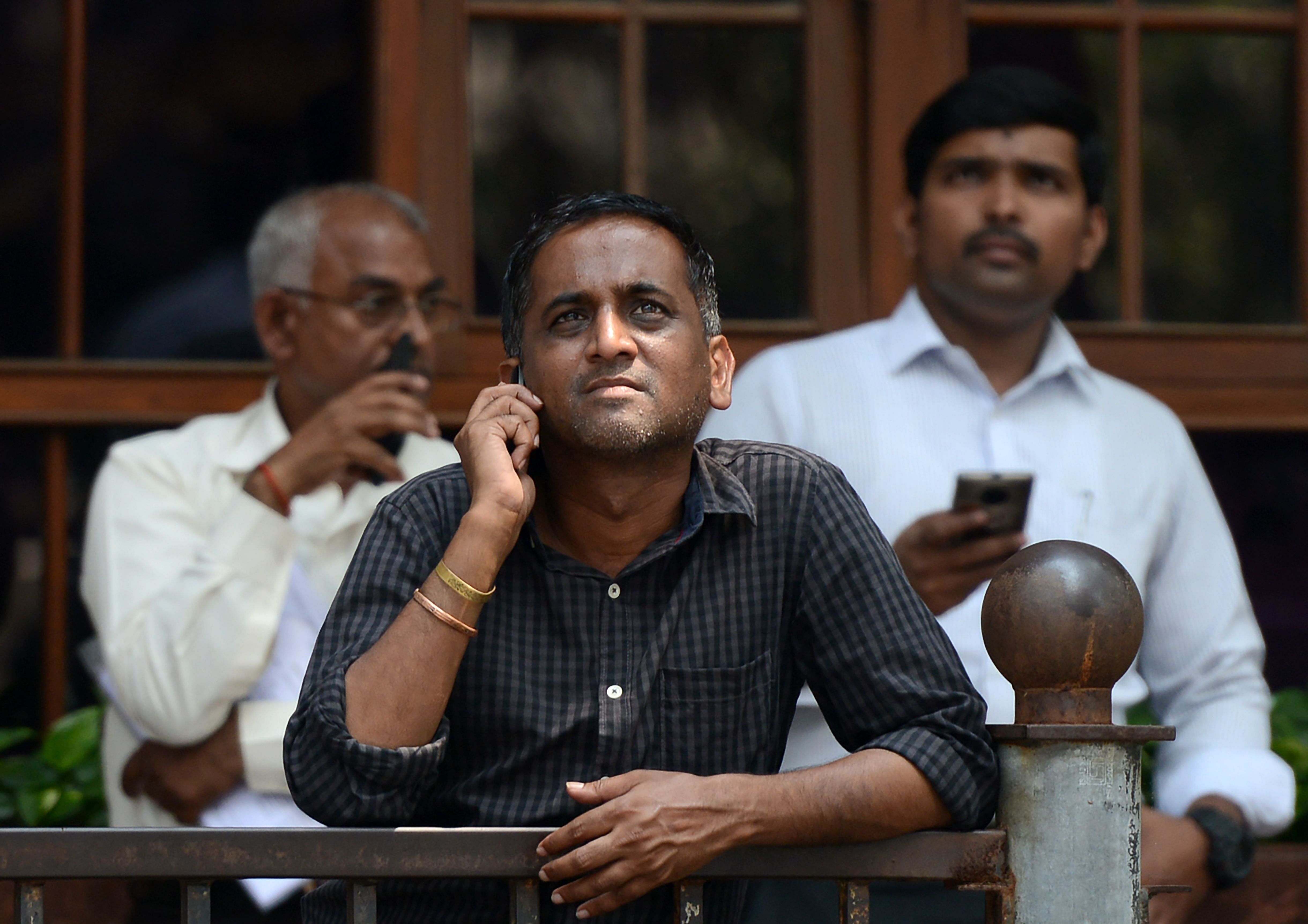 Indian men watch share prices on a digital broadcast outside the Bombay Stock Exchange (BSE) in Mumbai. (AFP Photo)