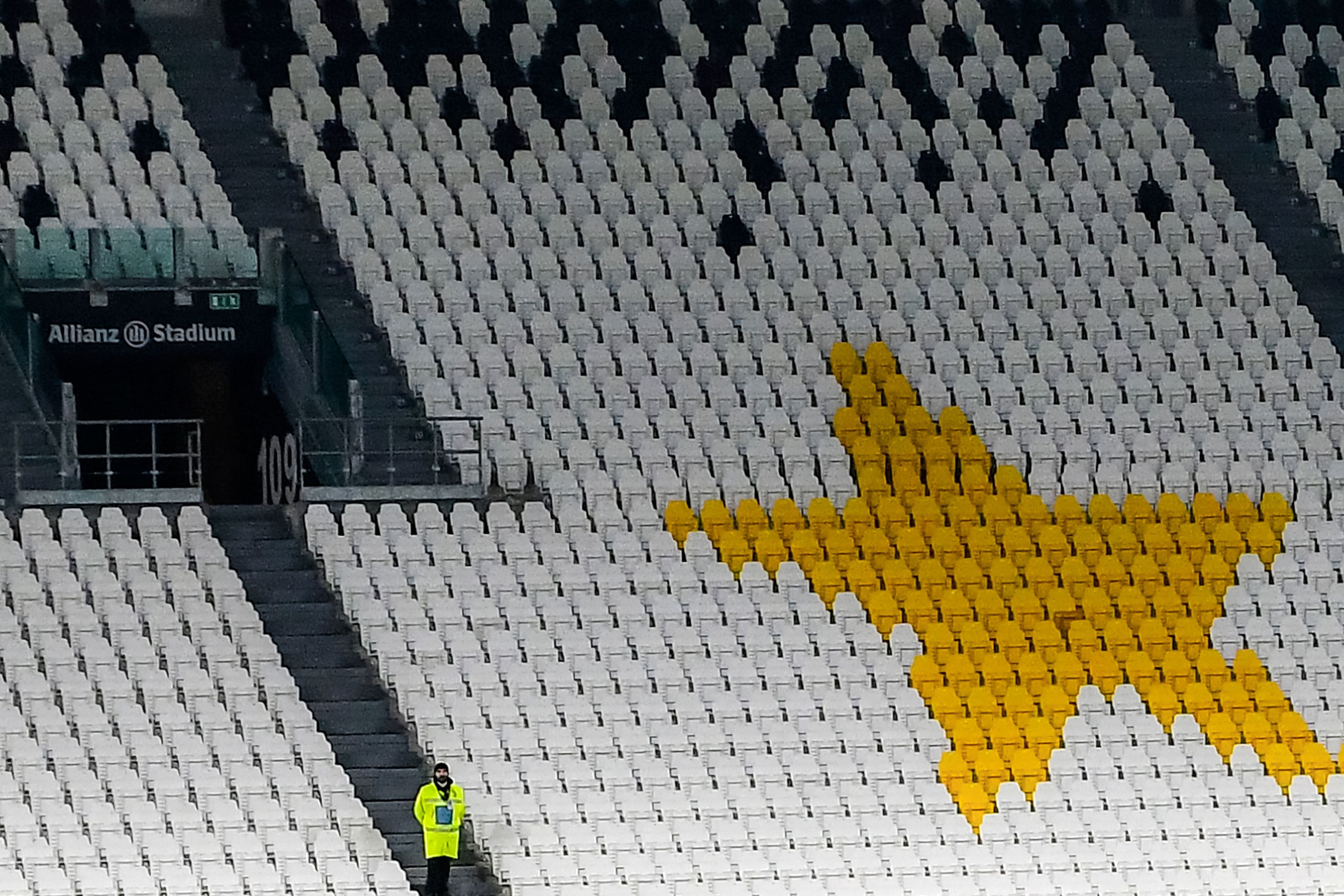 A stewart (Bottom L) stands in an empty tribune of the Allianz Juventus stadium on March 8, 2020 in Turin during the Italian Serie A football. (AFP Photo)