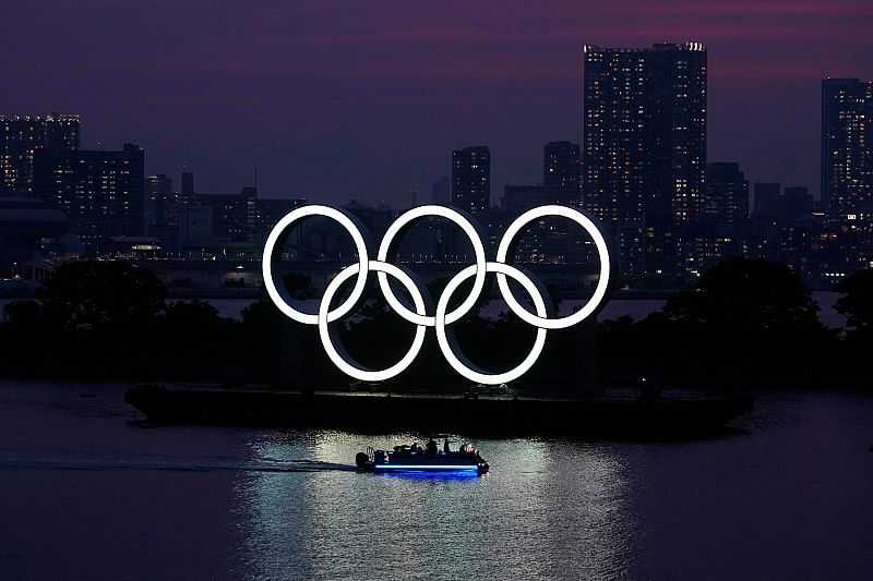  The Olympic rings float in the water at sunset in the Odaiba section. (AP Photo)