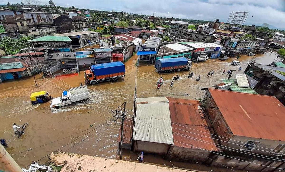 Vehicles ply on a flooded street following incessant torrential rains, during the ongoing COVID-19 nationwide lockdown, in Silchar. (PTI Photo)
