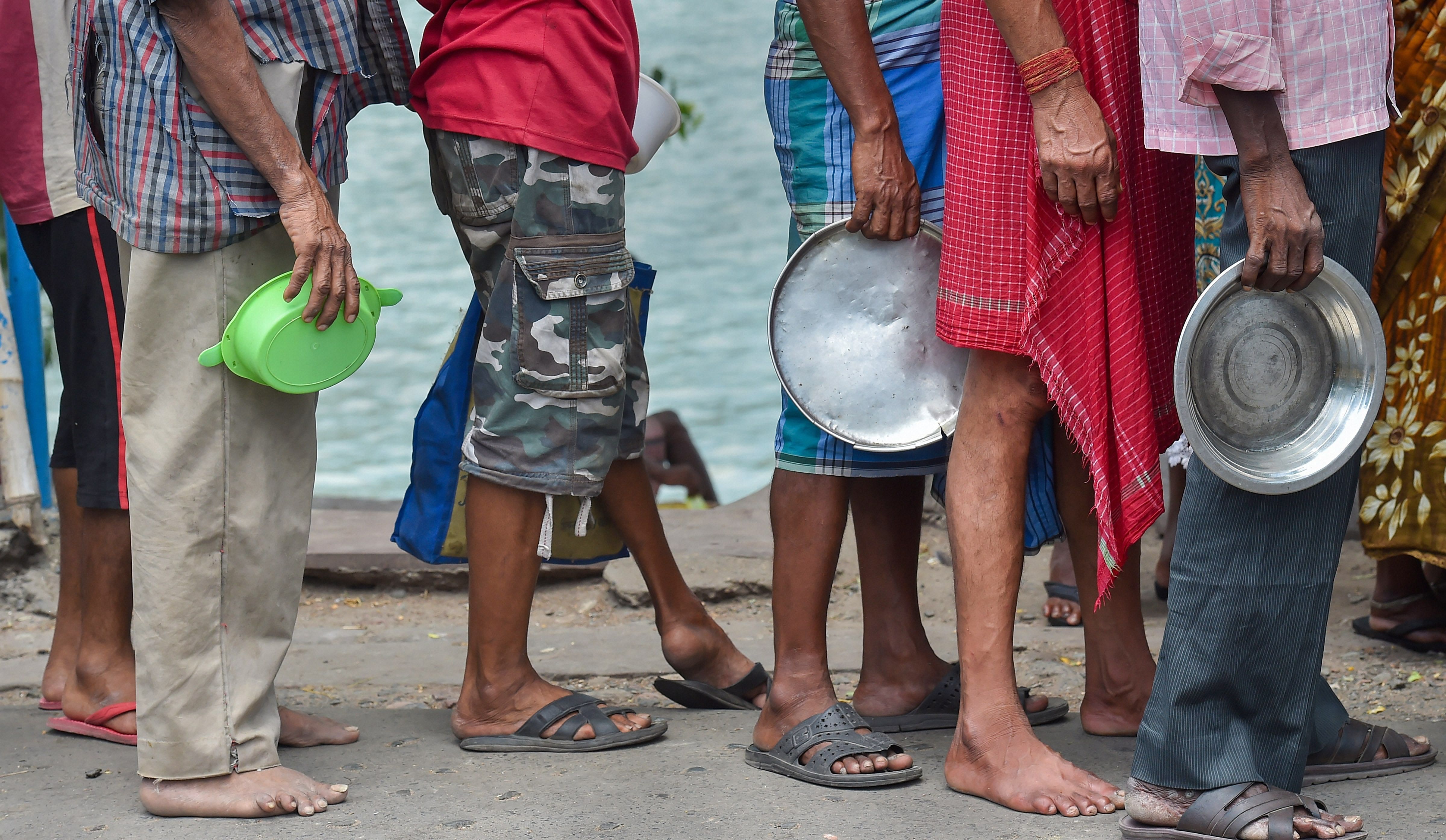 Poor people stand in a queue to collect food from volunteers during 4th phase of COVID-19 lockdown, in Kolkata. Credit: AFP Photo