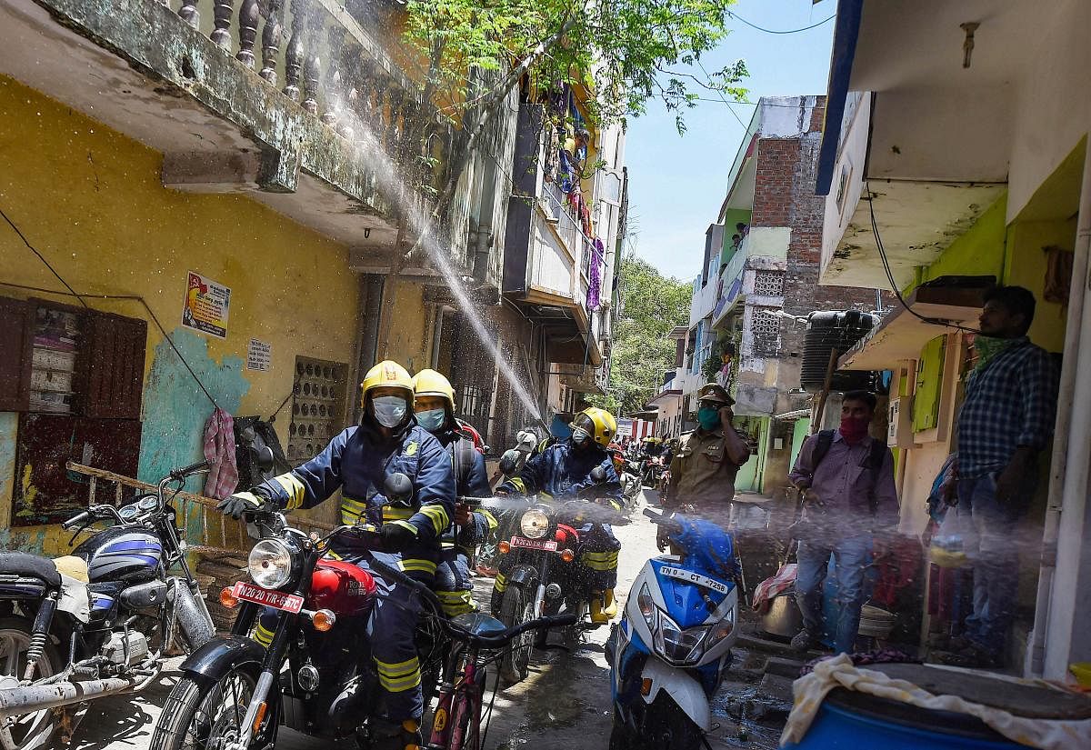 Firefighters riding motorbikes spray disinfectants in a containment zone, during the fifth phase of ongoing COVID-19 nationwide lockdown, in Chennai. PTI