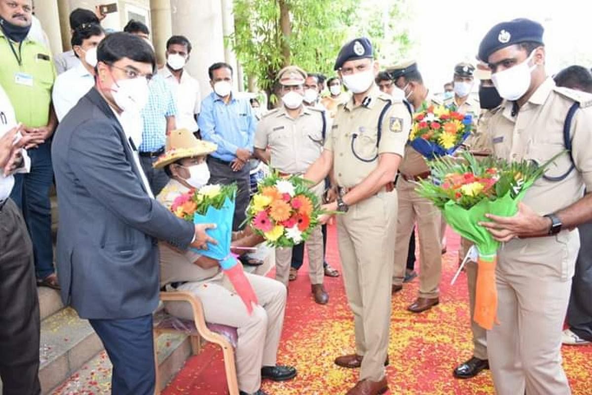 IGP (Southern Range) Vipul Kumar felicitates head constable Nagaraju, who battled Covid-19, during his discharge in Mandya on Friday. SP K Parashuram and Deputy Commissioner M V Venkatesh are also seen. DH PHOTO