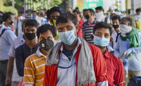 Railway porters wearing face mask wait to board a train at New Delhi Railway Station, during COVID-19 lockdown 5.0, in New Delhi, Monday, June 1, 2020. (Credit: PTI Photo)