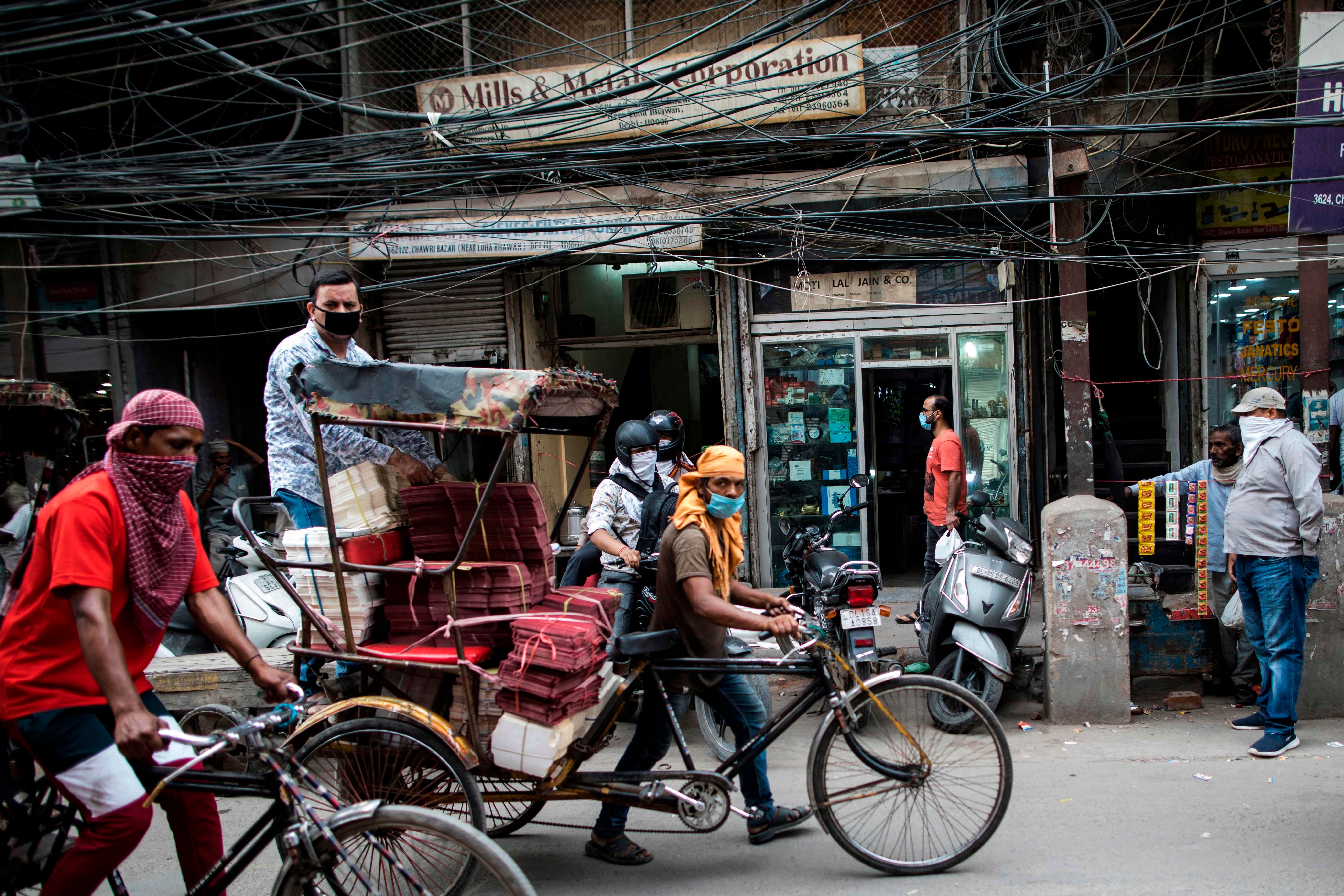 Rickshaw drivers make their way along a street after the government eased a nationwide lockdown imposed as a preventive measure against the COVID-19 coronavirus. (AFP Photo)