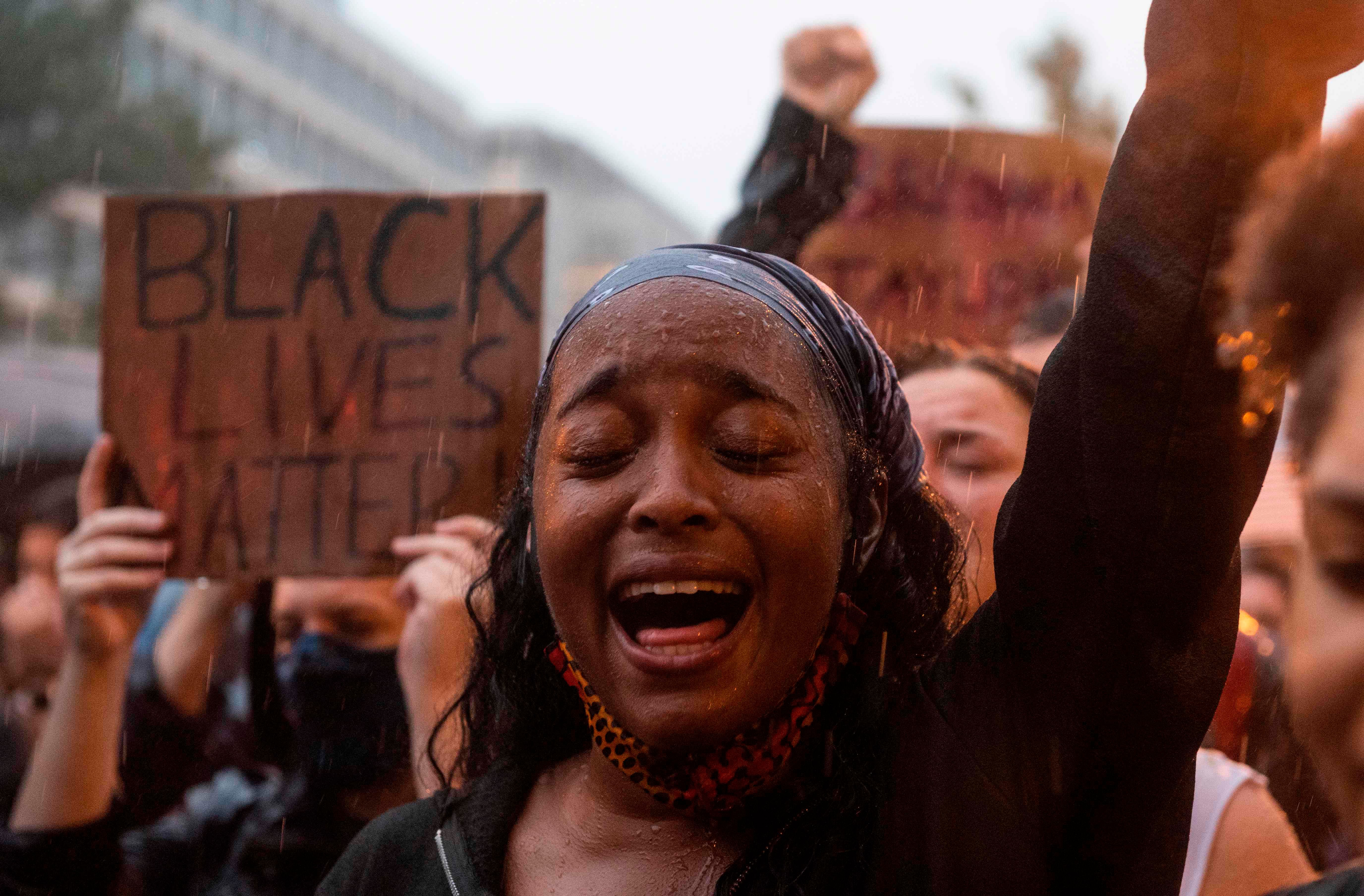 A protester shouts "Black Lives Matter" during a rain storm in front of Lafayette Park next to the White House on June 5, 2020. - Washington mayor Muriel Bowser on June 5 renamed an area near the White House that has become the epicenter of anti-racism protests over the past week "Black Lives Matter Plaza. (AFP Photo)