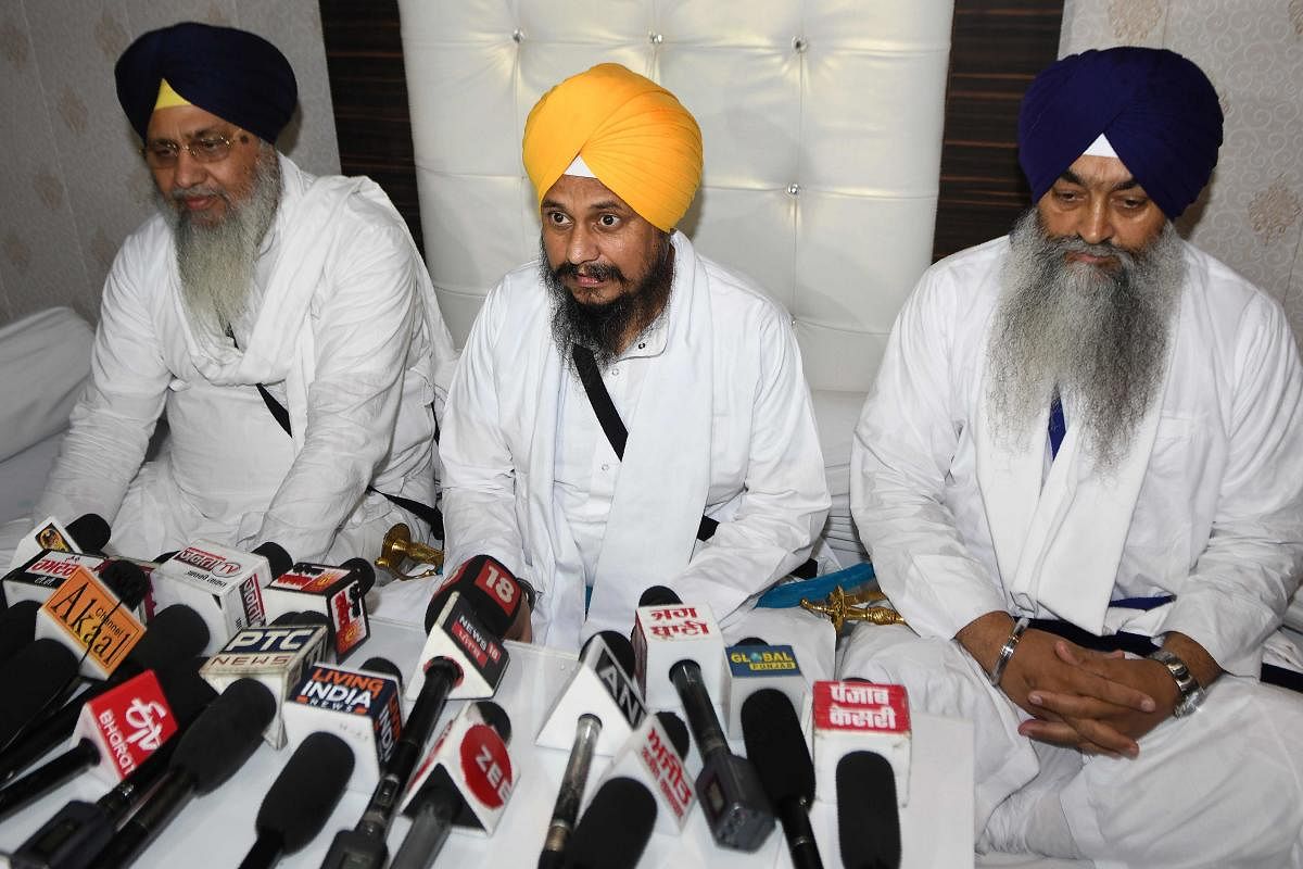 Jathedar (head priest) of the Akal Takht (seat of authority for Sikhs) Giani Harpreet Singh (C) and Shiromani Gurdwara Parbandhak Committee (SGPC) president Gobind Singh Longowal (L) speak to media persons after offering Ardas prayers, on the occasion of the 36th anniversary of Operation Blue Star, at the Golden Temple in Amritsar on June 6, 2020. Credit/AFP Photo