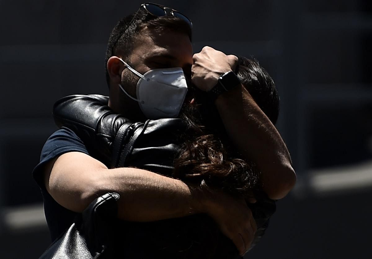 Travelers hug at Rome's Fiumicino airport on June 3, 2020, as airports and borders reopen for tourists and residents free to travel across the country, within the COVID-19 infection, caused by the novel coronavirus. Credit: AFP Photo
