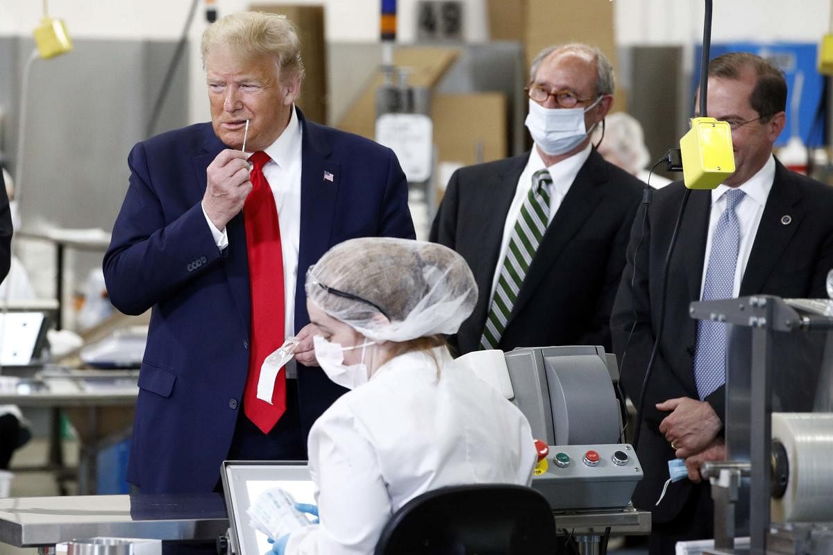 President Donald Trump holds a medical swab near his nose as he tours Puritan Medical Products, a medical swab manufacturer, Friday, June 5, 2020, in Guilford, Maine. AP/PTI Photo