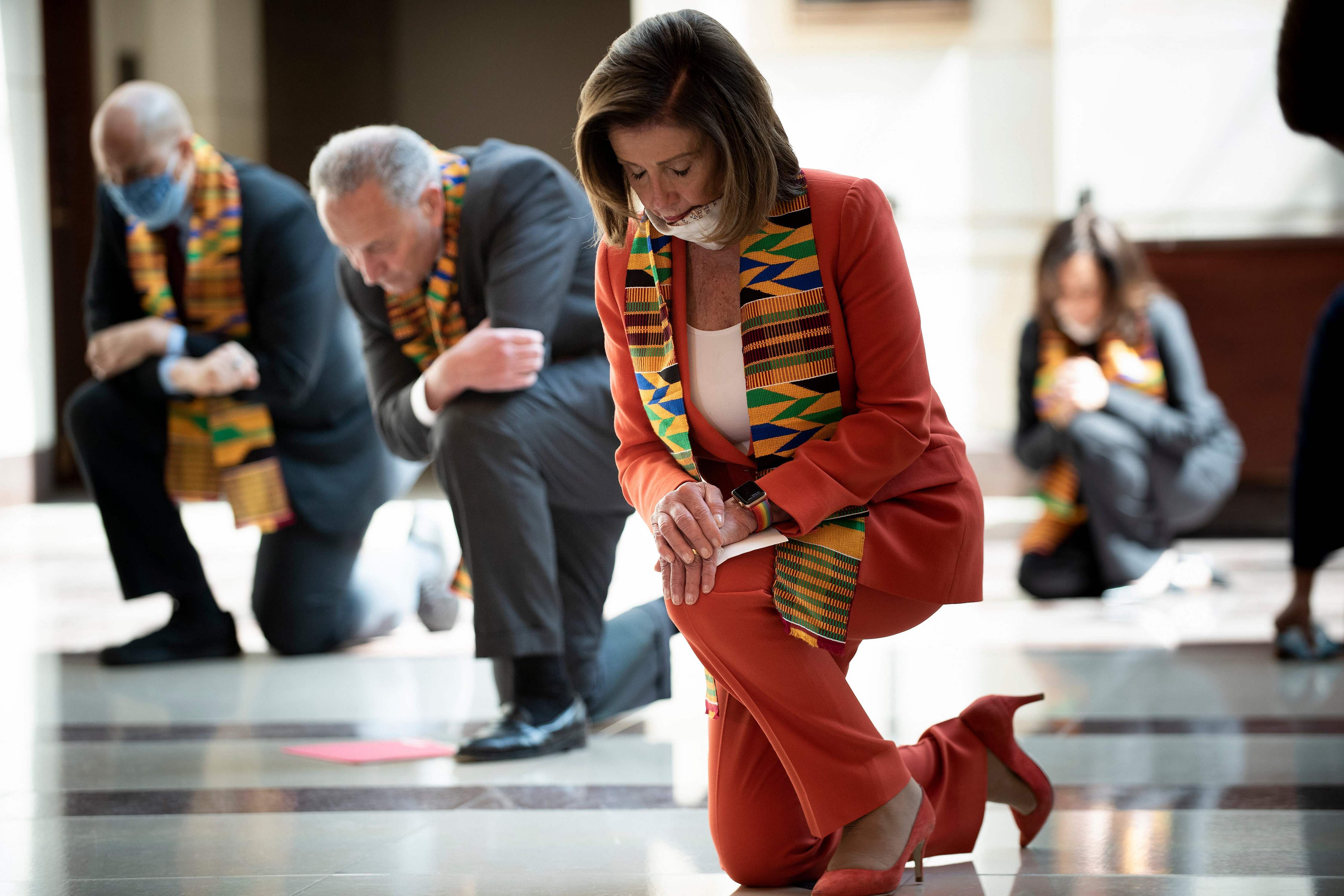 Speaker of the House Nancy Pelosi (D-CA) and other Democratic lawmakers take a knee to observe a moment of silence on Capitol Hill for George Floyd and other victims of police brutality. Credit: AFP Photo