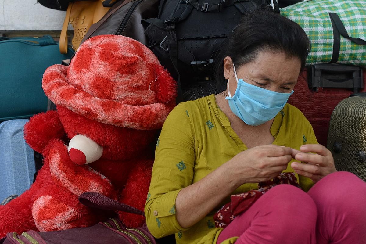 A stranded migrant labourer sits at an assembling centre to get transferred to railway station to board on a special train to Mizoram after the government eased a nationwide lockdown imposed as a preventive measure against the COVID-19 coronavirus, in Chennai. Credit: AFP file photo