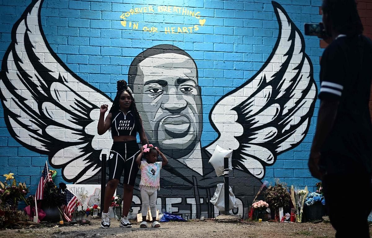 People stand in front of a mural of George Floyd in Houston, Texas on June 8, 2020. Credit/AFP Photo