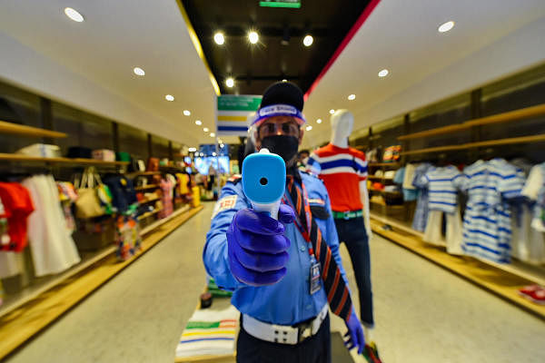 New Delhi A security person holds an infrared thermometer for the thermal screening of visitors at Select Citywalk after the authorities permitted to reopen malls, in New Delhi, Monday, June 8, 2020. Credit: PTI Photo