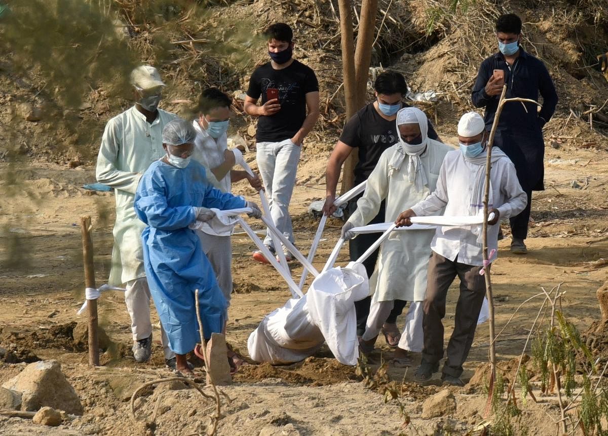 Relatives perform last rites of a family member who died of COVID-19, during the ongoing nationwide lockdown, in New Delhi, Tuesday, June 9, 2020. Credit/PTI Photo