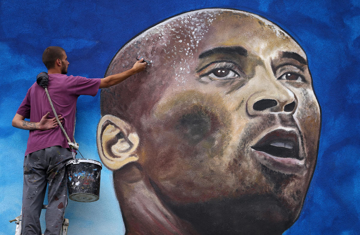 Artist Deni Bozic (27) paints the last details on his tribute mural honoring former Los Angeles Lakers basketball star Kobe Bryant on a school building wall in Gradiska, Bosnia and Herzegovina. Credit: Reuters