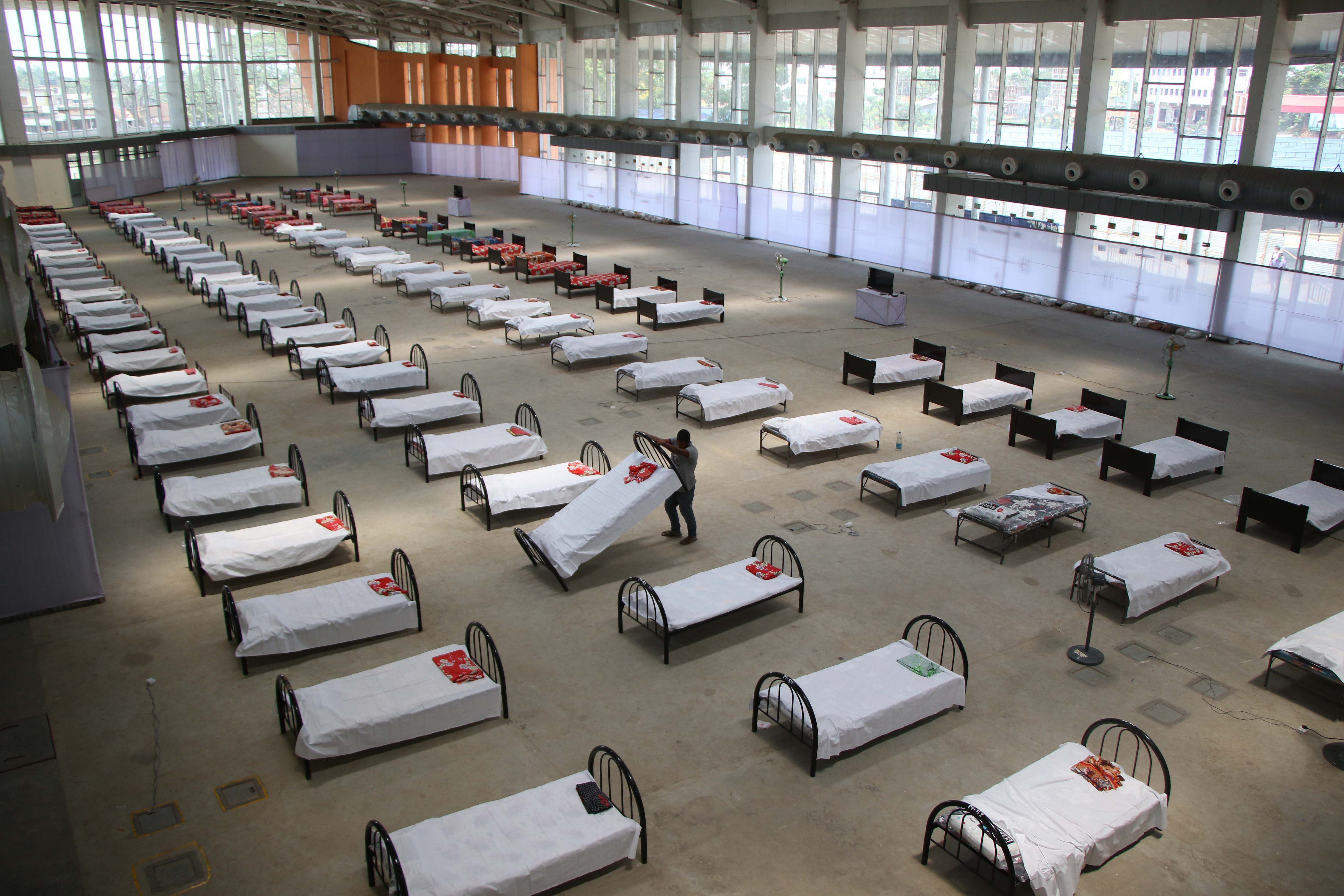 A worker arranges beds at quarantine centre set up in the Hapania International Fair Complex during a nationwide lockdown imposed as a preventive measure against the COVID-19. Credits: AFP Photo
