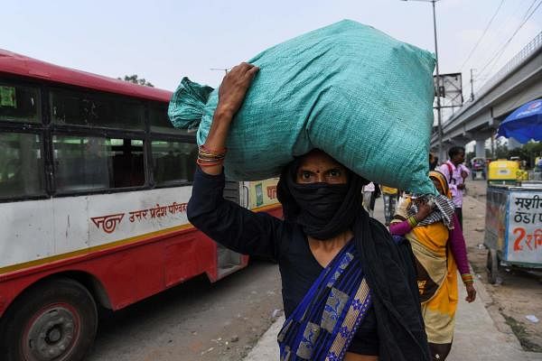 A migrant worker carries her belongings in a sack on her head as he leaves a bus station upon returning from her village after the government eased a nationwide lockdown imposed as a preventive measure against the COVID-19 coronavirus in Ghaziabad on June 10, 2020. Credit: AFP Photo