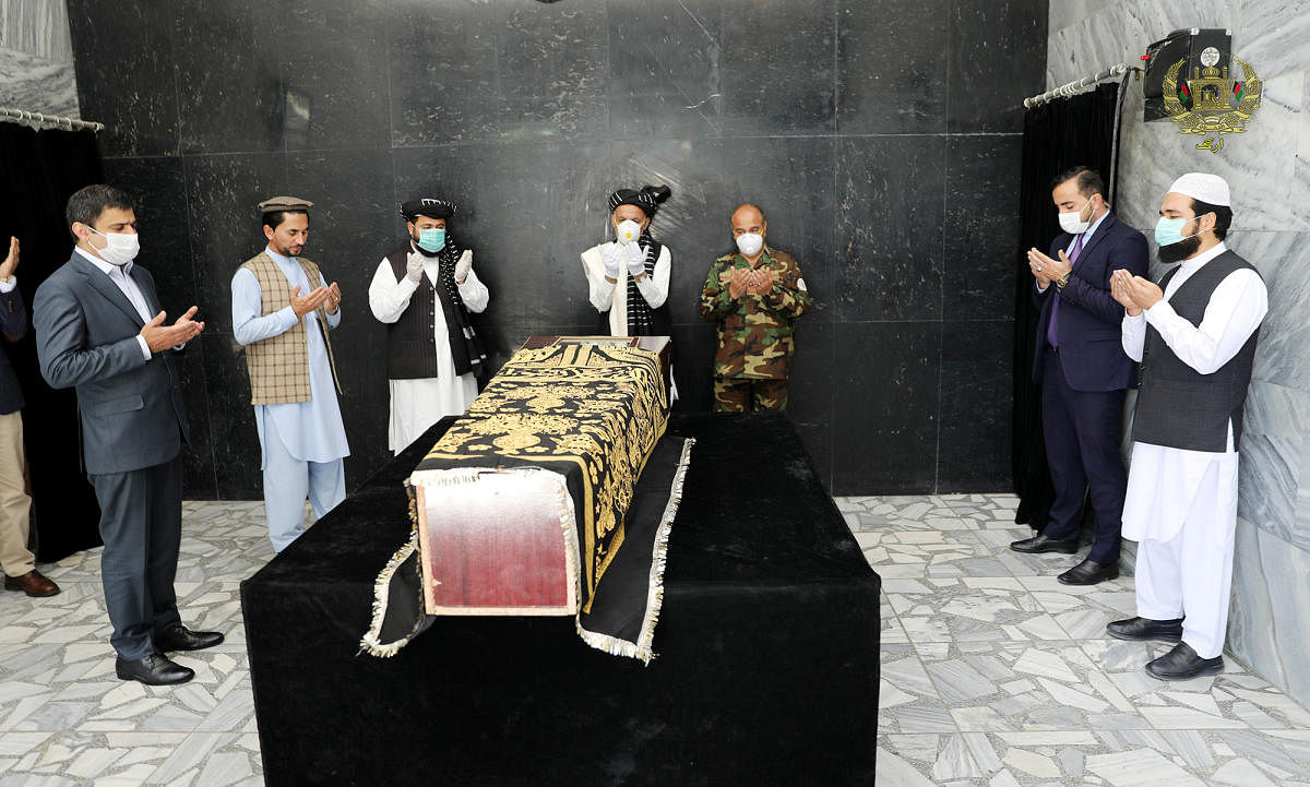 Afghanistan's President Ashraf Ghani prays over the coffin of Ayaz Niazi, a well-known scholar, who was killed last night by a bomb blast in Kabul (Reuters Photo)