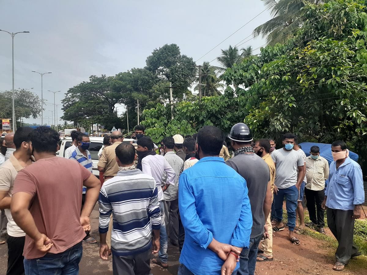 The crowd mills around a well in Puttur where Vittal Naik’s body was found on Thursday.
