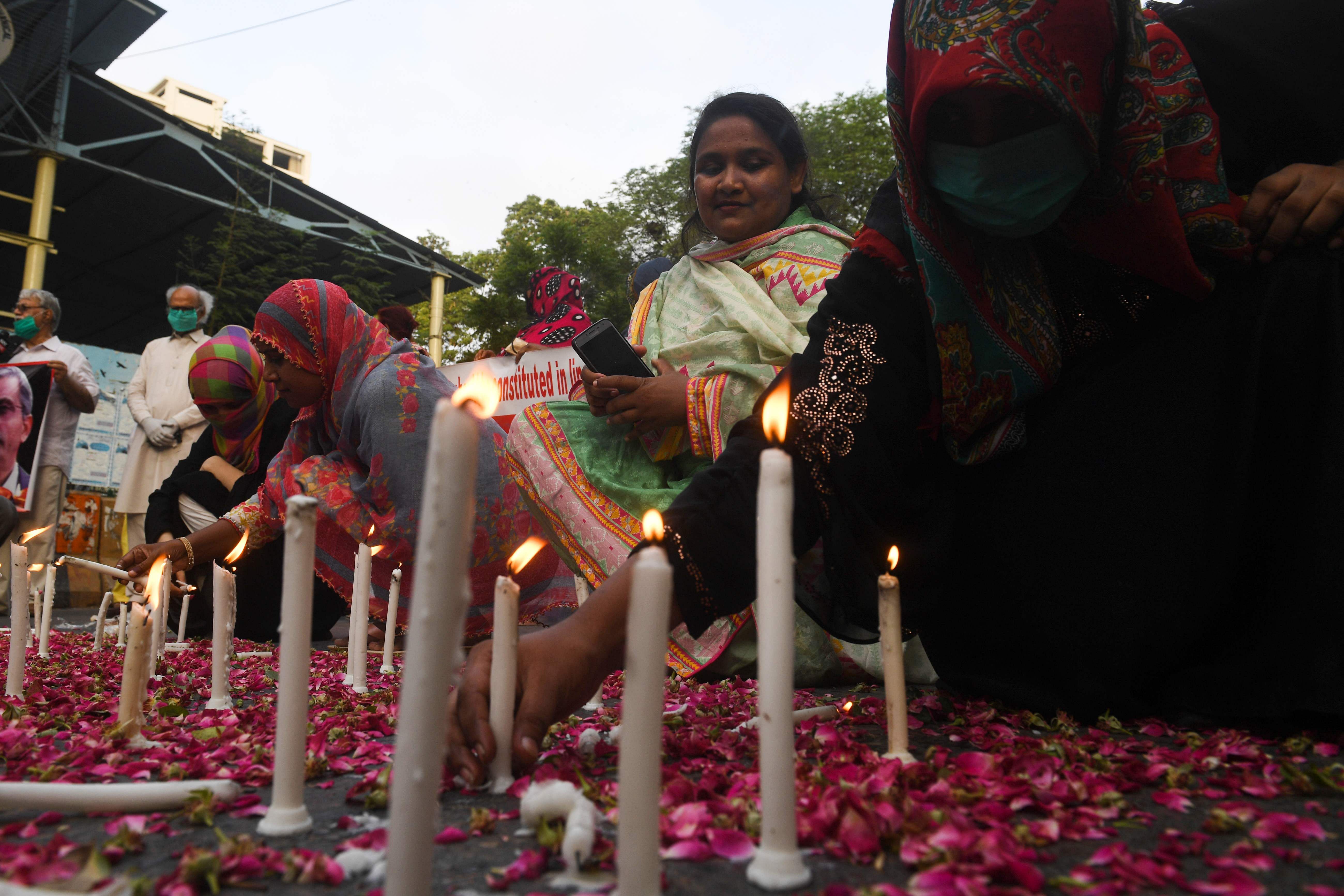 Trade union and civil society activists light candles in Karachi on May 28, 2020, during a candlelight vigil for the victims of the Pakistan International Airlines (PIA) plane crash. Credits: PTI Photo