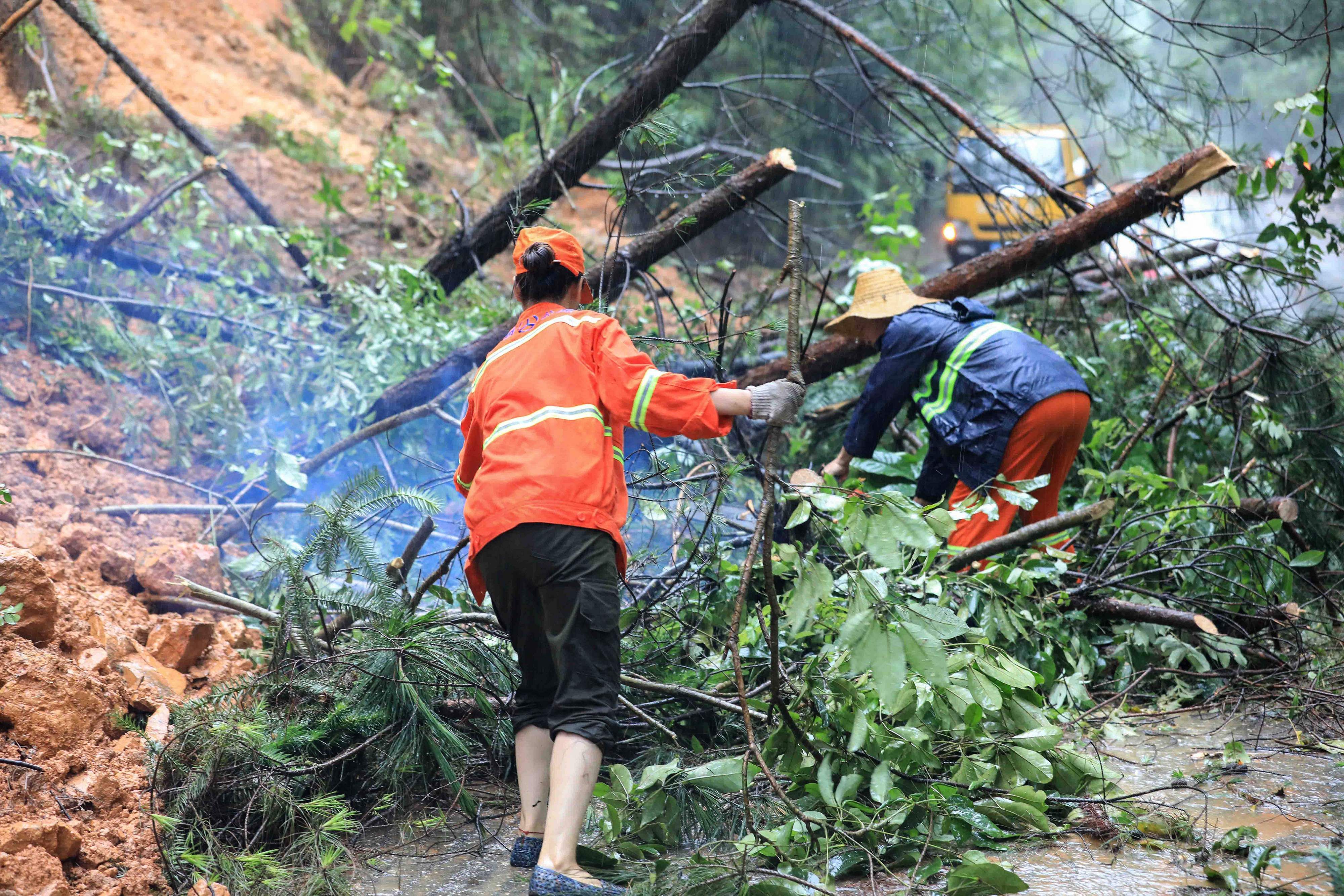 Workers clearing up branches following a landslide caused by heavy rain in Rongan in China's southern Guangxi region. Credits: AFP Photo