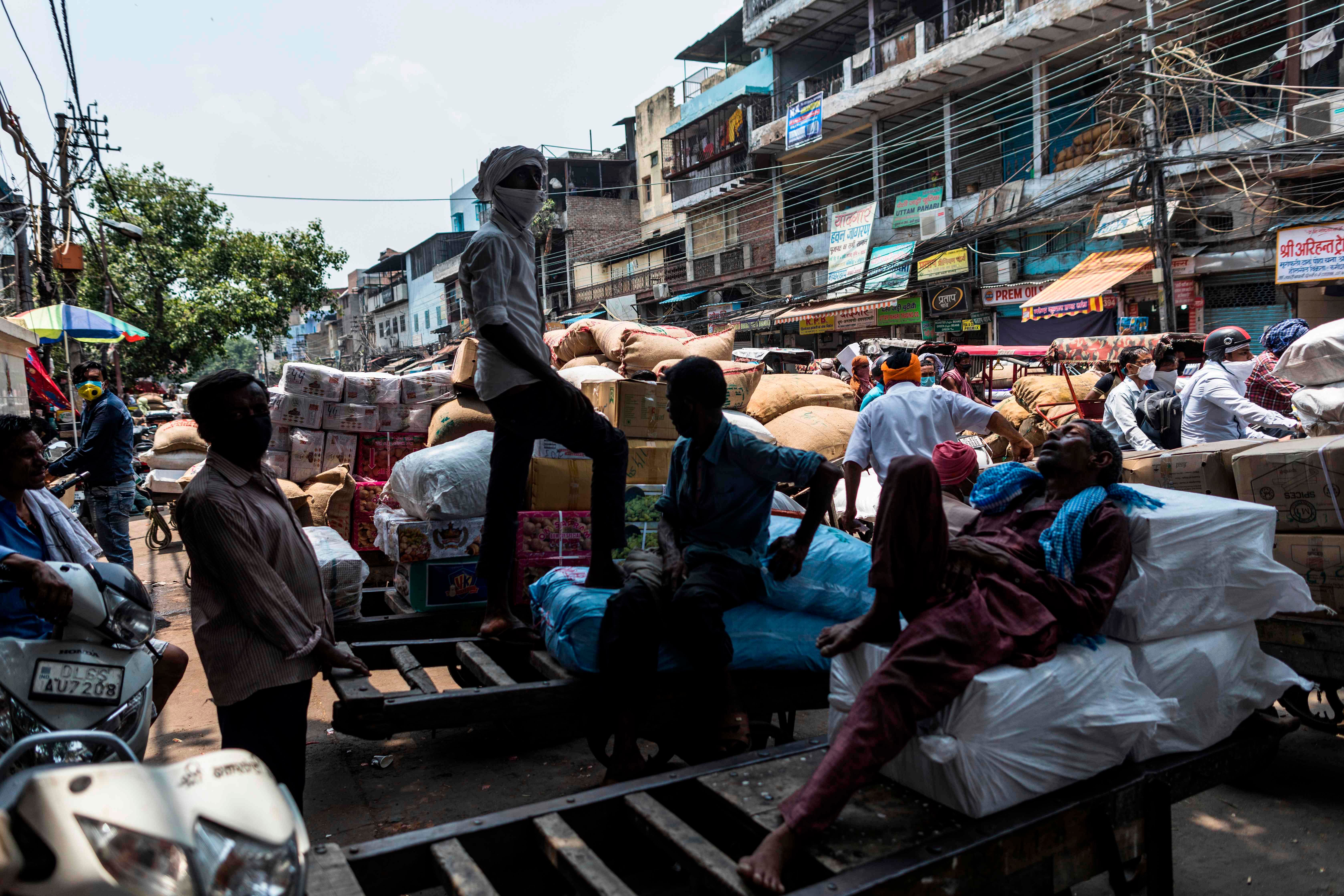 Workers rest on handful carts in Fatehpuri Market after the government eased a nationwide lockdown imposed as a preventive measure against the COVID-19 coronavirus in New Delhi. Credits: AFP Photo