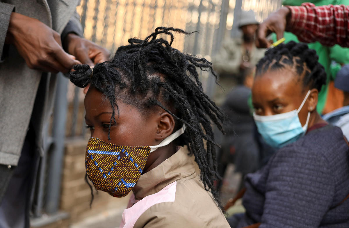 Customers are attended to by roadside hairdressers, openly flouting lockdown regulations amid the spread of the coronavirus disease (COVID-19), in Johannesburg. Credit: Reuters