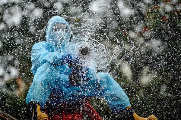 A firefighter sprays disinfectant as a preventive measure against the spread of the COVID-19 coronavirus in a containment zone in Chennai on May 11, 2020. Credit: AFP Photo