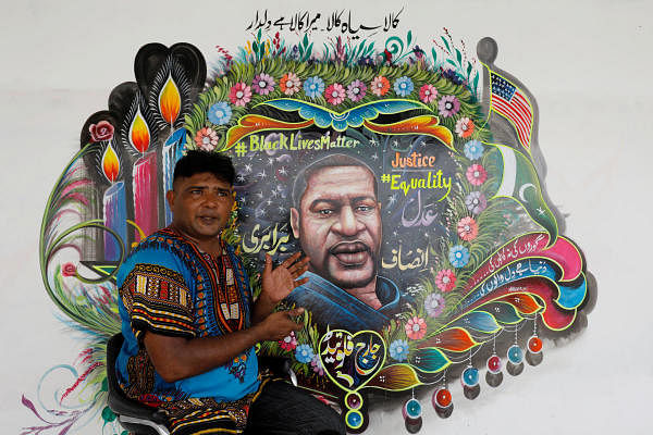 Pakistani truck-art painter Haider Ali, 40, gestures next to a mural he painted, depicting George Floyd, who died in Minneapolis police custody in U.S., in Karachi, Pakistan, June 12, 2020. Credit: REUTERS Photo
