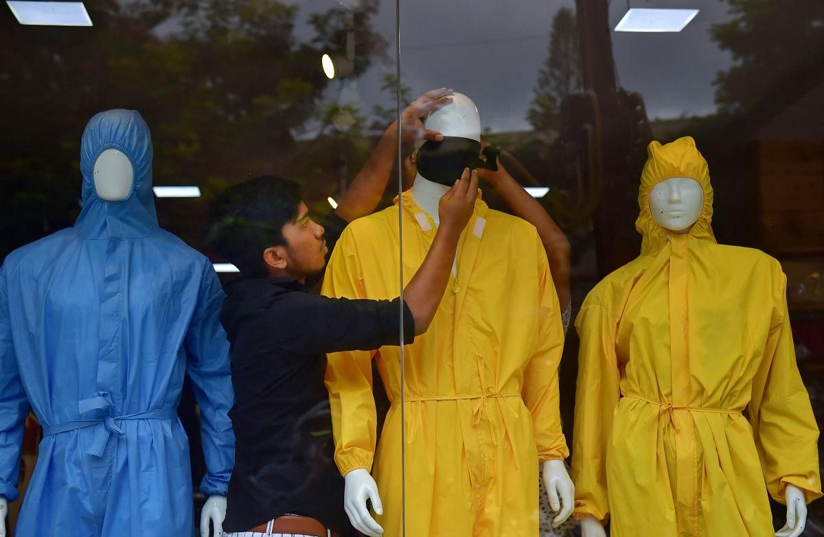 A salesman arranges a face mask on a mannequin at a store after the authorities permitted opening of apparel stores, during the ongoing COVID-19 nationwide lockdown, in Bengaluru, Wednesday, June 10, 2020. Credit/PTI Photo