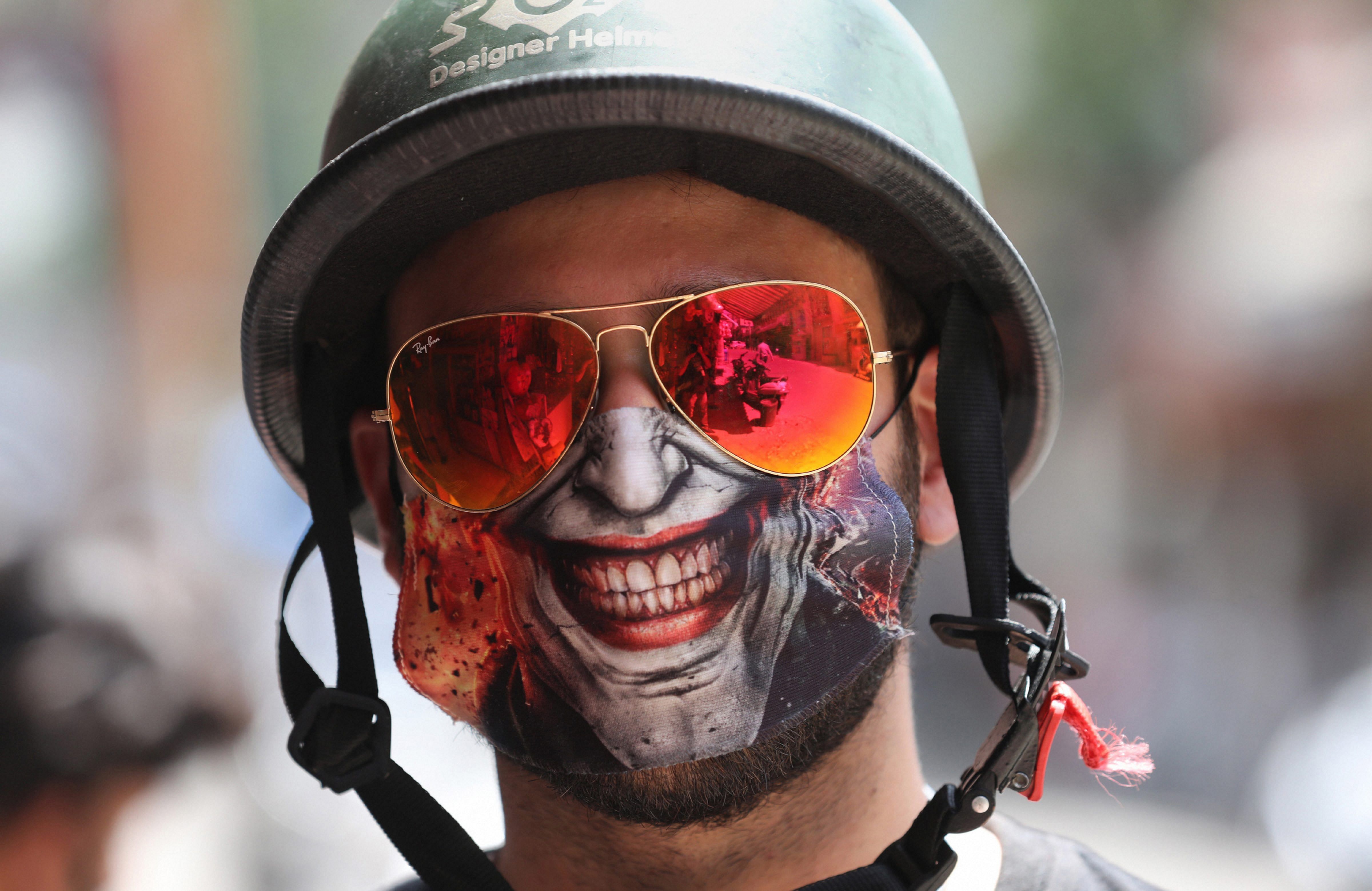 A youngster wearing a designer face mask poses for photographs, during the ongoing COVID-19 nationwide lockdown, in Jammu. Credit: PTI Photo