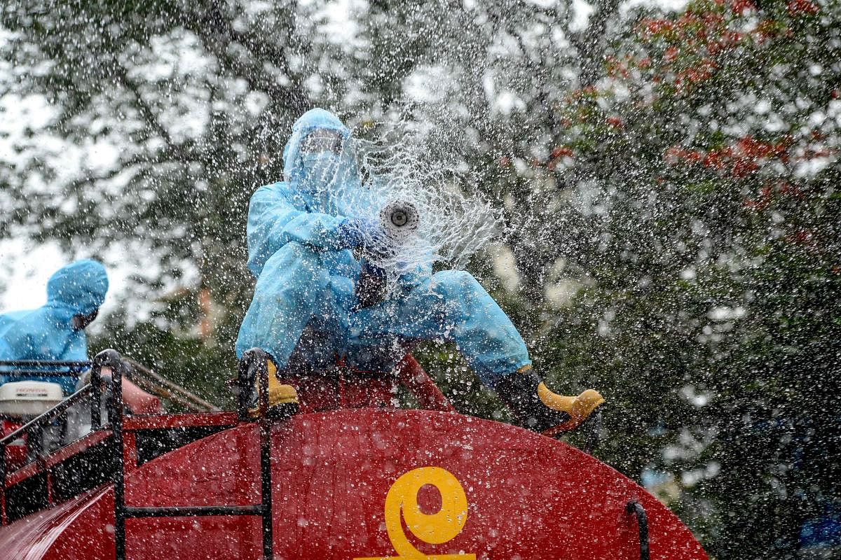 A firefighter sprays disinfectant as a preventive measure against the spread of the COVID-19 coronavirus in a containment zone in Chennai (AFP Photo)