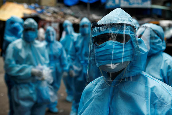 Healthcare workers wait to take off their personal protective equipment (PPE) after the end of a check-up camp for the coronavirus disease (COVID-19) at a slum in Mumbai, India June 14, 2020. Credit: Reuters Photo