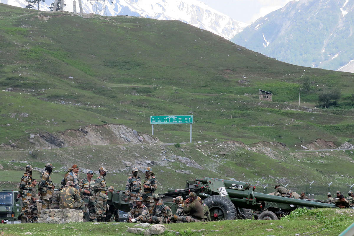 Indian army soldiers rest next to artillery guns at a makeshift transit camp before heading to Ladakh, near Baltal, southeast of Srinagar, June 16, 2020. REUTERS