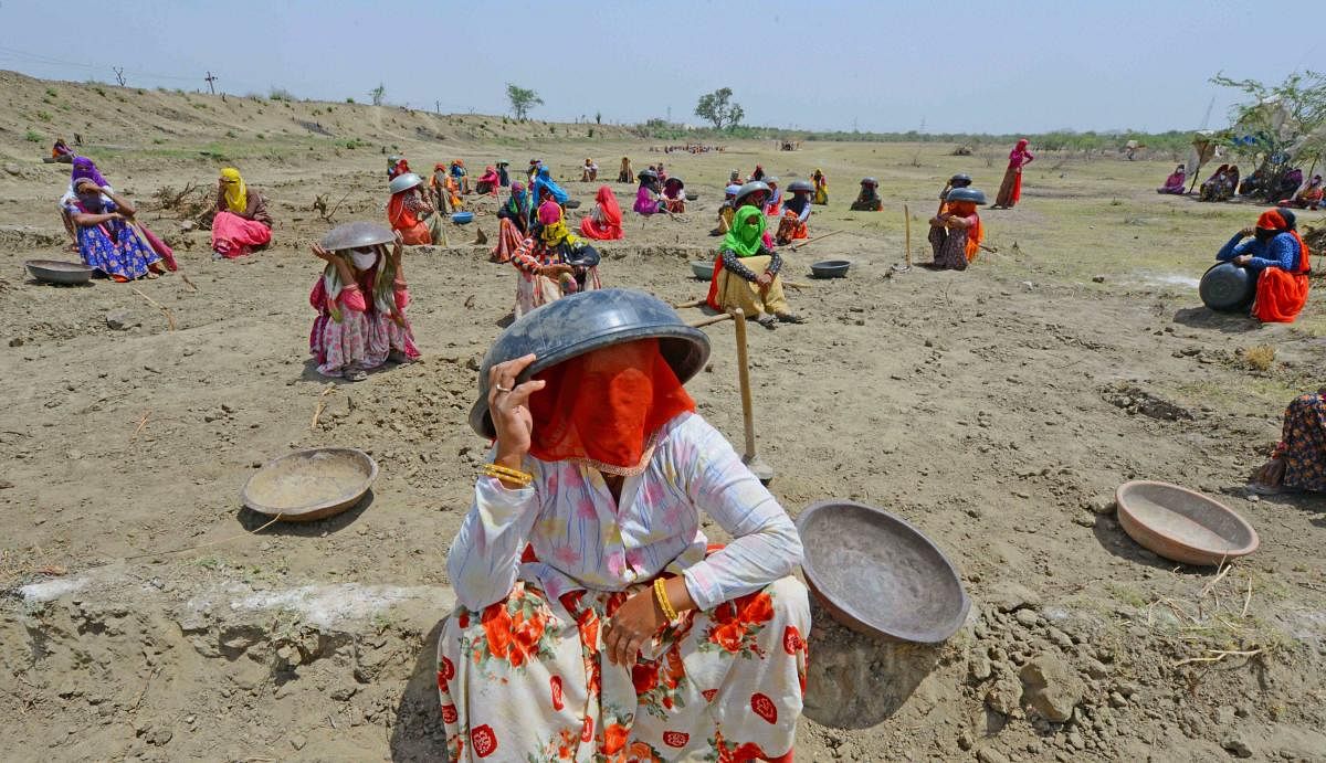 Labourers under MNREGA sit under tagaris to protect themselves against the scorching sun (PTI Photo)