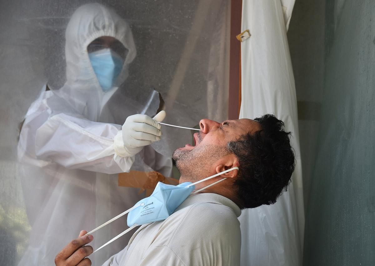A health worker collects swab sample for the COVID-19 test (PTI Photo)