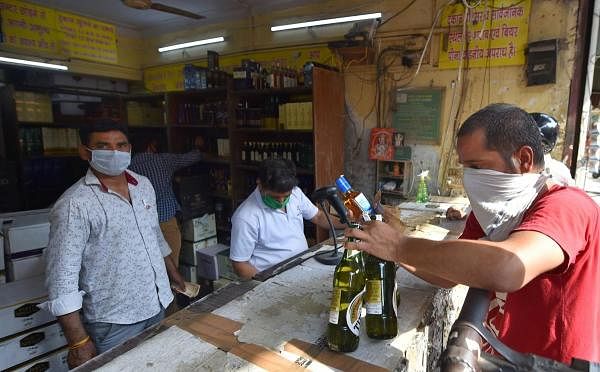 People buy liquor from a wine shop at Chander Nagar, during the ongoing COVID-19 lockdown, in East Delhi, Wednesday June 10, 2020. Delhi government has removed 70% corona tax on liquor prices. (PTI Photo)