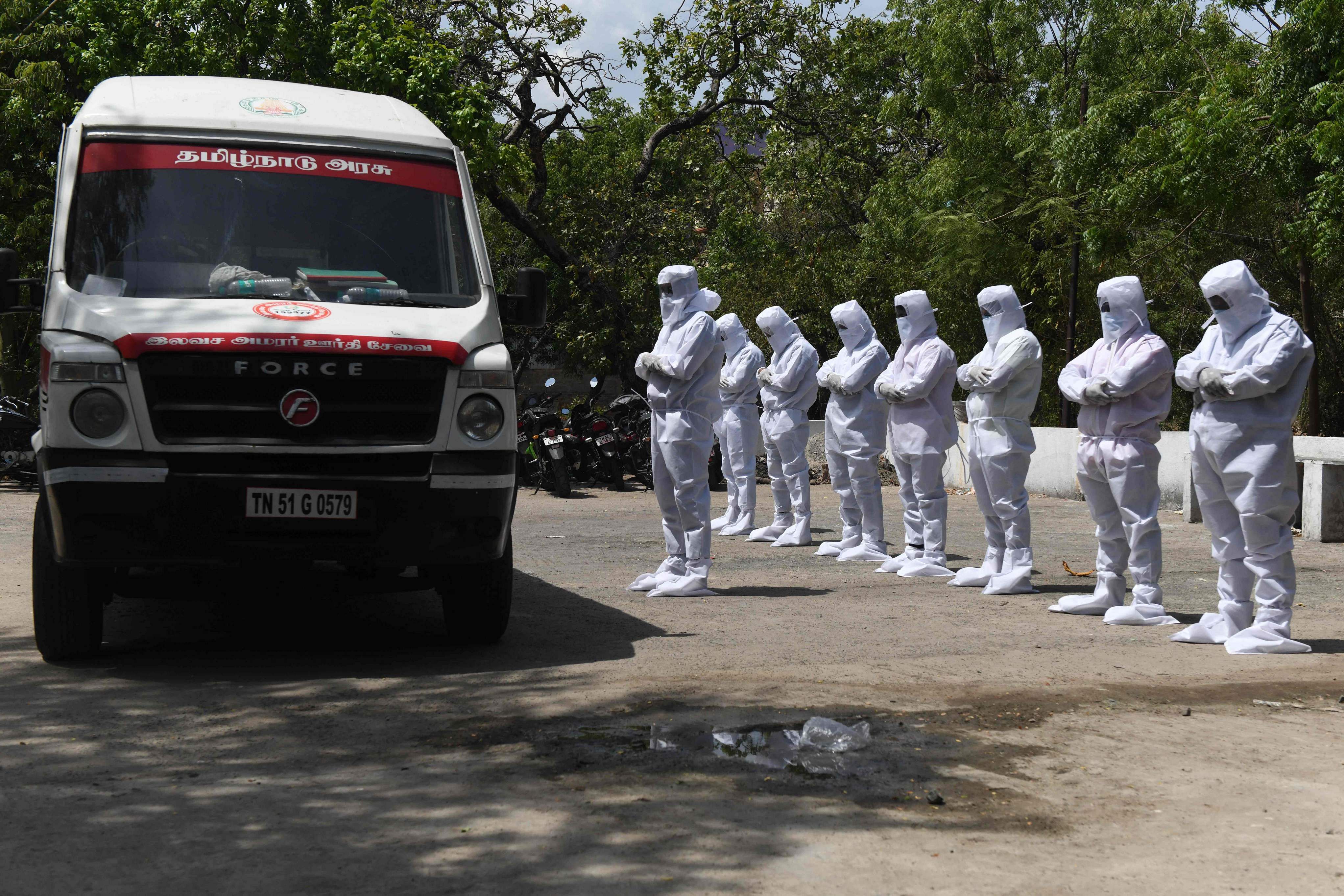 Volunteers of the Social Democratic Party of India wearing a protective gear offer funeral prayers in front of an ambulance carrying abandoned bodies of victims who died from the COVID-19 coronavirus, at a graveyard in Chennai. Credit: AFP Photo