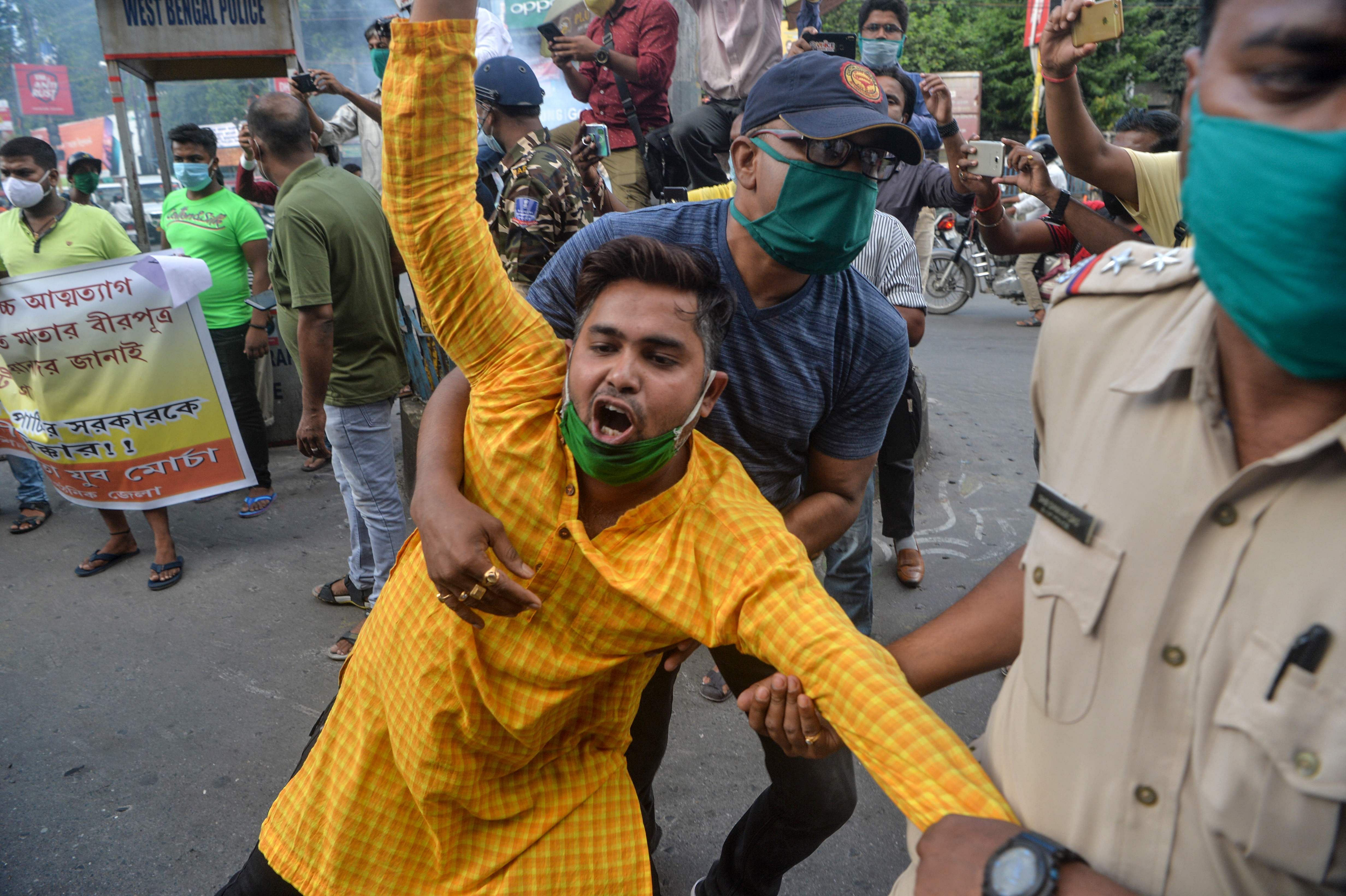 Police personnel catch activists of BJP as they shout slogans during an anti-China protest in Siliguri on June 17, 2020.  (AFP Photo)