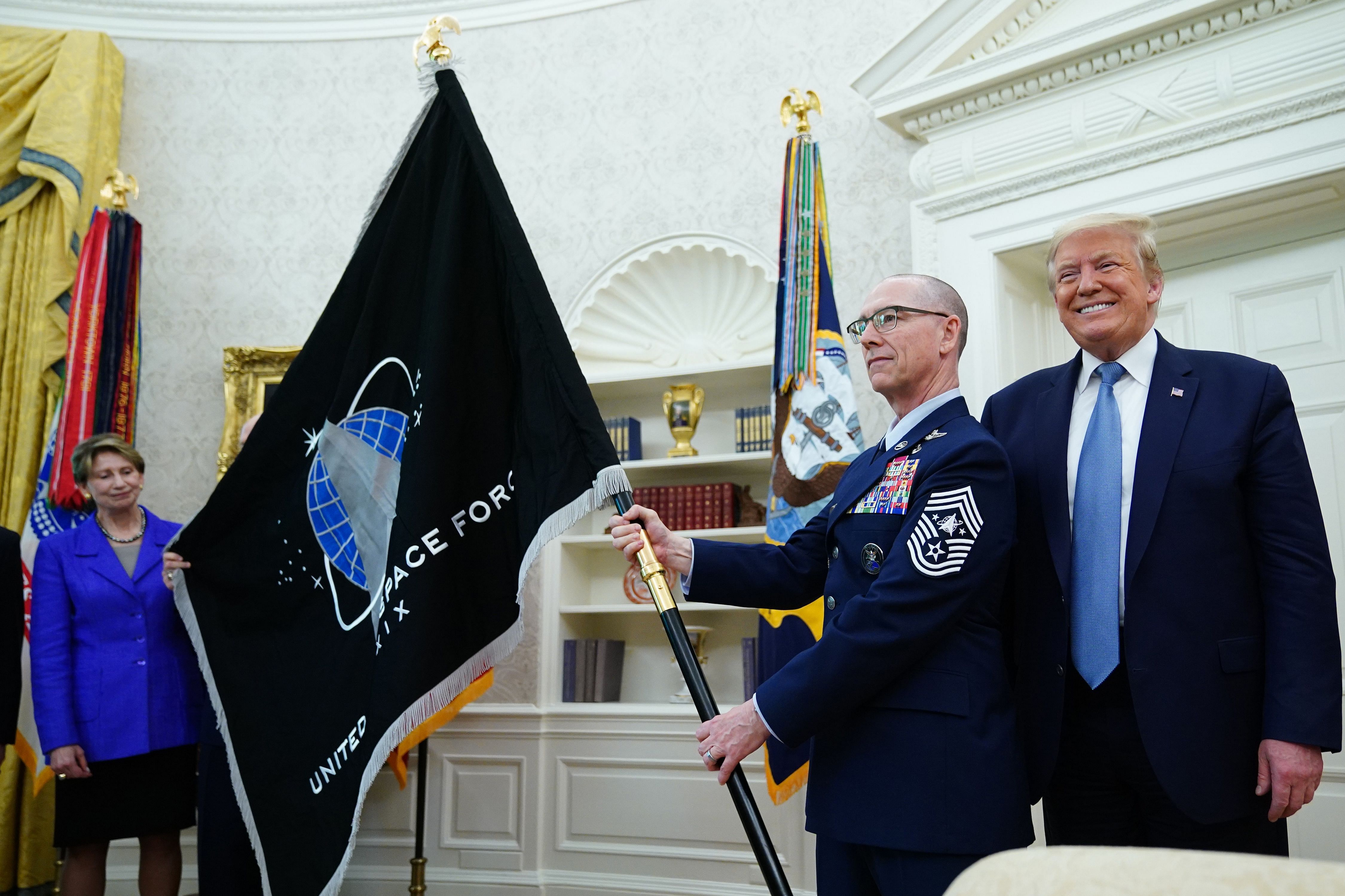 US Space Force Senior Enlisted Advisor CMSgt Roger Towberman, with US President Donald Trump, presents the US Space Force Flag in the Oval Office of the White House. Credit: AFP Photo
